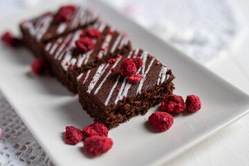 rich dark cocolate brownie cake desert with freeze dried raspsberries 