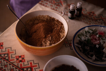 hands of a woman mixing ground walnut with cocoa, raisins and Turkish delicacies in the kitchen. preparing a traditional cake recipe at home