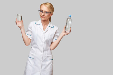 Healthy eating or lifestyle concept - female woman doctor holding and a glass of clear fresh water