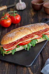 Sandwich with prosciutto, tomatoes, arugula and cheese. Healthy eating. Diet.