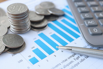 Document with commercial indicators in coins and calculator is on desktop