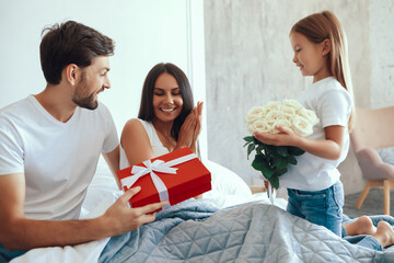 Excited young mother recieving attention and presents from family