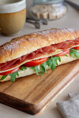 Sandwich with prosciutto, tomatoes, arugula and cheese. Healthy eating. Diet.