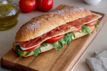 Sandwich with prosciutto, tomatoes, arugula and cheese. Healthy eating. Diet.