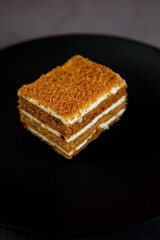 cake on a black dessert plate on a black marble table. Dessert on a black background.