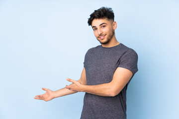 Arabian handsome man over isolated background extending hands to the side for inviting to come