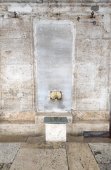 Ablution or wudu station at mosque in Istanbul, Turkey. Faucets for ritual ablution and stones to sit on near a mosque in Islamic culture. Turkish Ottoman style water tap.