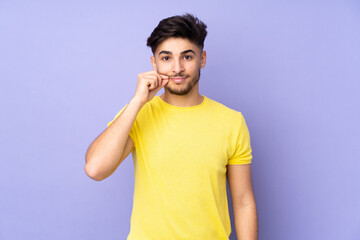 Arabian handsome man over isolated background showing a sign of silence gesture