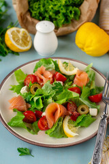 Fresh summer salad with smoked salmon, lettuce, cherry tomato and olives