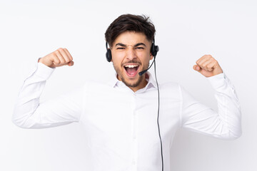 Telemarketer Arabian man working with a headset isolated on white background celebrating a victory