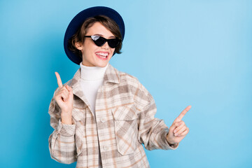 Photo of girl have fun dance direct fingers wear checkered coat retro hat sunglass isolated blue...
