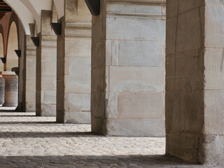 View from the side on stone columns at the town hall of Lucerne, Switzerland, with cobblestone pavement