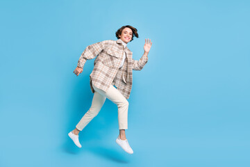 Profile full size photo of optimistic cool lady run wave hand wear shirt trousers sneakers isolated on teal color background