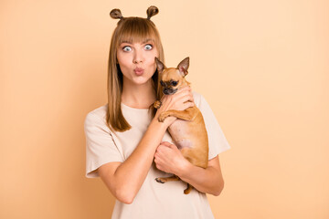 Photo portrait of model with pouted lips keeping chihuahua dog isolated on pastel beige color background