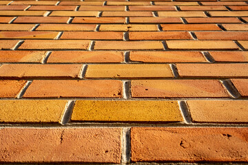 perspective view of a textured brown and orange brick wall. brick background