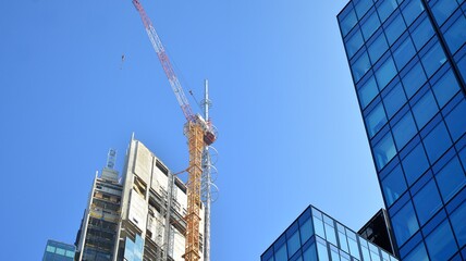 View of a skyscraper under construction. Modern architecture background. Building a high-rise building,  the concept of real estate construction. 