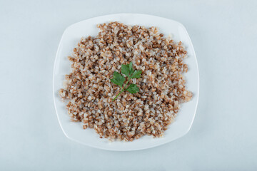 Delicious buckwheat with greens on a white plate