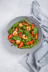 Salad of shrimp prawn and fresh vegetable, leaves of arugula, lettuce.
