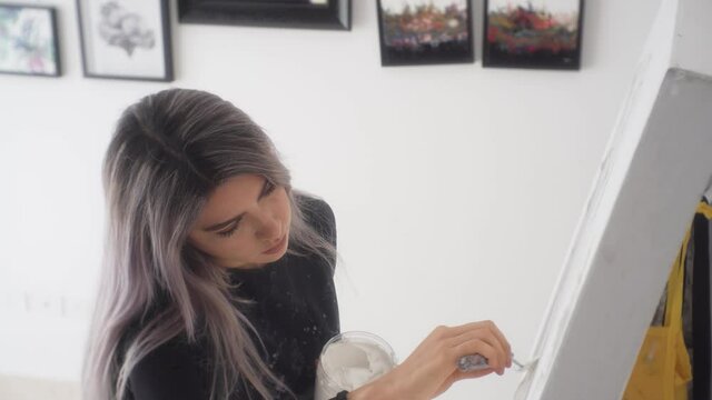 Beautiful Latina Artist With A Palette Knife Doing An Abstract Painting. - Medium Shot