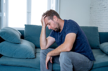Young man suffering from depression feeling lonely, distressed and hopeless isolated at home