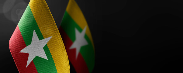 Small national flags of the Myanmar on a dark background