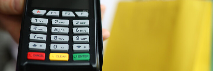 Man hold cash register close up on background of packages with purchases. Cashless payment for goods by credit card. Sale of cash registers.