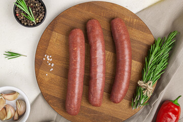 Raw meat beef sausages for grill and spicy, herbs rosemary, pepp