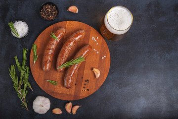 Raw meat beef sausages for grill and spicy, herbs rosemary, pepper, salt on table