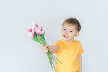 Obraz na płótnie Canvas Boy holding a bouquet with tulips in their hands. Children congratulate on the holiday