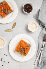 Jellied meat with horseradish on grey table