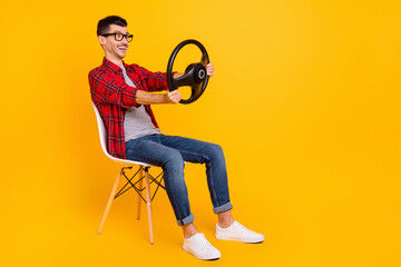 Photo of funny man wear checkered shirt eyewear sitting chair holding steering wheel empty space...