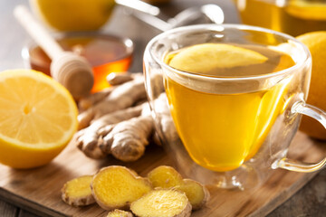 Ginger tea with lemon and honey in crystal glass on wooden table	