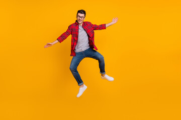 Fototapeta na wymiar Full size photo of young happy excited smiling positive man in glasses jumping isolated on yellow color background