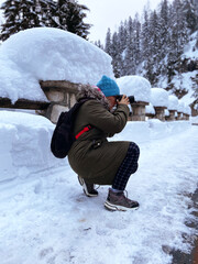 Fototapeta na wymiar Nature woman landscape photographer in warm clothing taking picture photos with DSLR camera on Kranjska Gora, Slovenia. Winter activities. Winter holidays. 