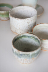 Turquoise handmade cups. Kitchen tea set on a white table. Minimalistic set of dishes