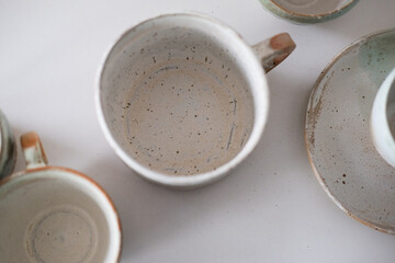 Turquoise handmade cups. Kitchen tea set on a white table. Minimalistic set of dishes