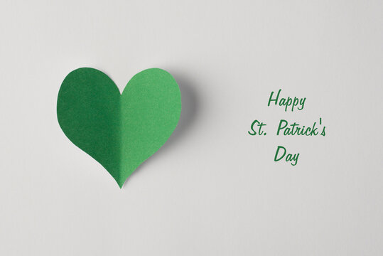 Closeup view photo of paper heart with shadow in green color isolated white color backdrop with text