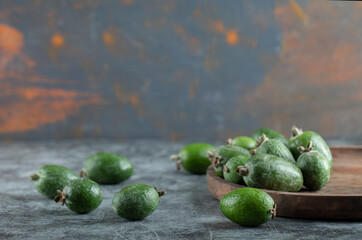 A wooden cutting board with fresh feijoa