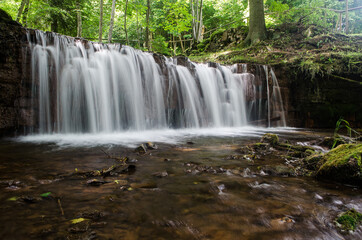 Obraz premium Long exposure Ierikupite waterfall flowing over the rock cascade, Ieriki, Latvia.
