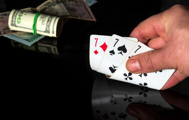 Poker cards with three of a kind, set combination. Close up of a gambler hand is holding playing cards in casino