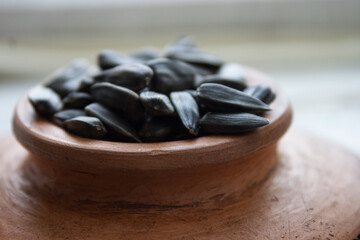 Unpeeled sunflower seeds in bowl isolated on white background. Top view.
