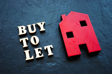 Buy to let and red wooden home on the stone.