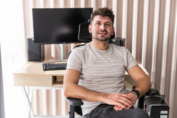 Young bearded man relaxing on chair while sitting in front of laptop at office