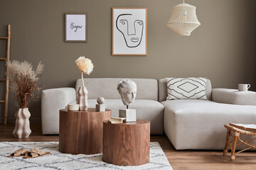 Interior design of stylish living room with modern neutral sofa, mock up poster farmes, dried flowers in vase, coffee tables, decoration and elegant personal accessories in home decor. Template.