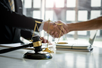 Businessman shaking hands to seal a deal with his partner lawyers or attorneys discussing a contract agreement.