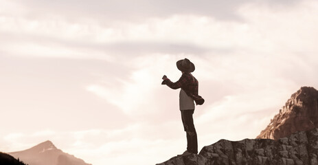 a hat wear men stand big rock sunset evening.