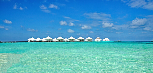 Fototapeta na wymiar Malediven Resorts mit Wasserbungalows, Paradies im Indischen Ozean mit puderzuckerweißen Stränden und türkis-blauem Meer.