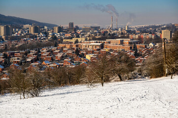 Northeastern part of city Zlin with typical red brick houses, snowy hill.