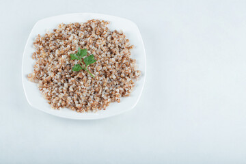 Delicious buckwheat with greens on a white plate