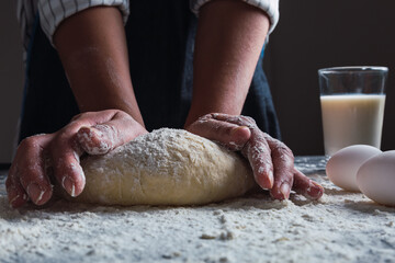 Fototapeta premium Close-up of a cook's hands kneading dough.